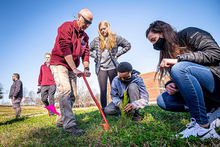 MSU Staff and students alongside of middle schoolers plant trees